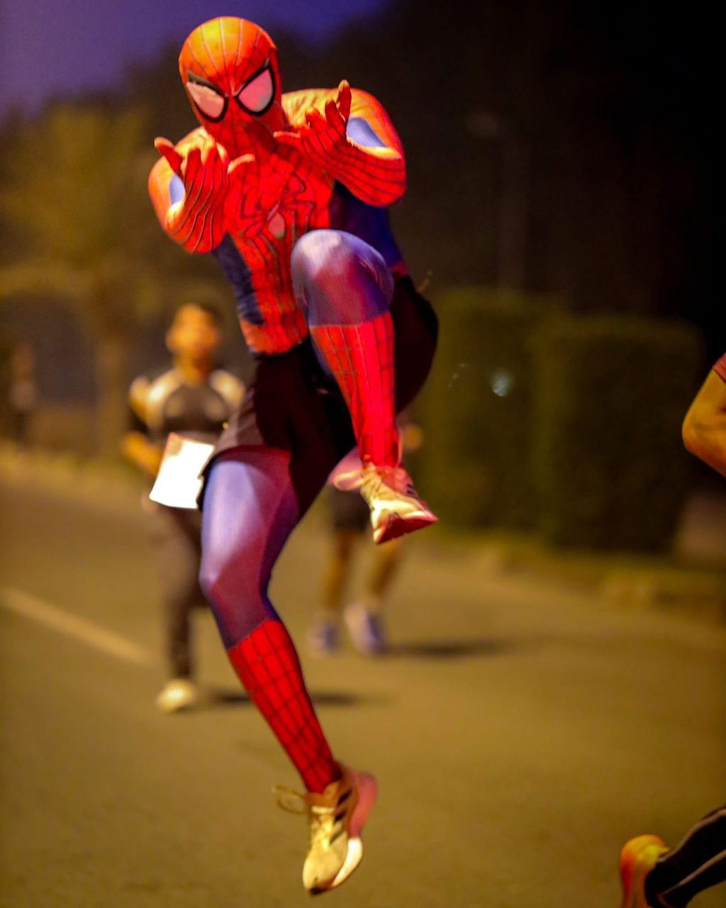 A runner in a Spider-Man costume mid-stride